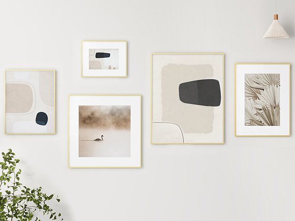 Gallery wall of five gold-framed abstract art prints and a photograph of a swan in fog