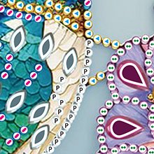 Close-up of a 5D diamond painting kit with hummingbird design, showing colorful crystal rhinestones and printed symbols.