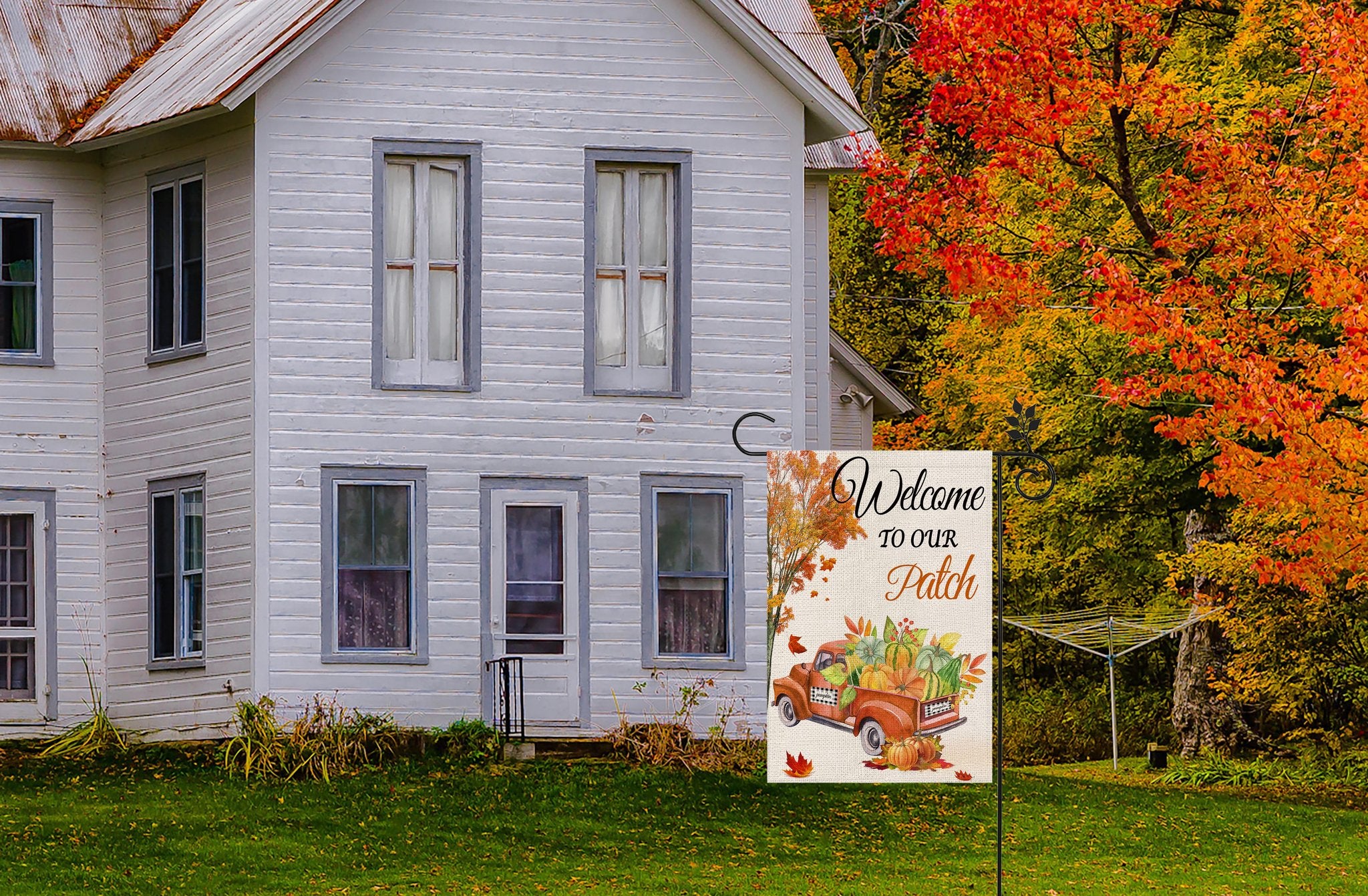Fall garden flag with a vintage truck full of pumpkins and gourds, set against a rustic house and autumn foliage.