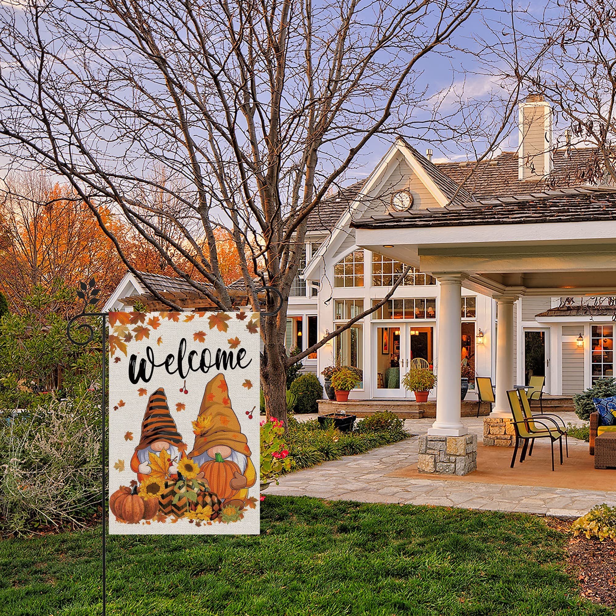 Fall garden flag with gnomes and pumpkins displayed in front of a house