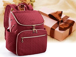 Quilted burgundy knitting backpack with gold zippers and side pockets, next to a gift box with a ribbon.