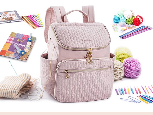 Pink quilted knitting backpack surrounded by yarn, crochet hooks, knitting needles, and a crochet book.
