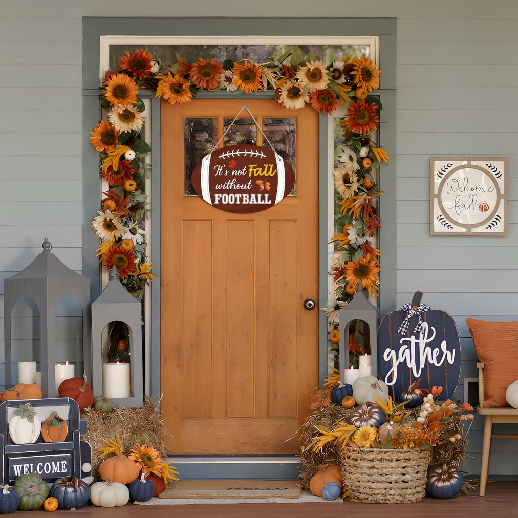 Front door decorated for fall with a football-shaped sign saying 'It's not Fall without FOOTBALL'.