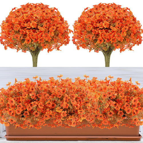 Two bunches of artificial orange flowers with green leaves and one planter filled with artificial orange flowers