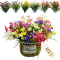 Artificial daisy flowers in mixed colors arranged in a woven basket with a 'Flowers' label and a '12 Bundles' tag.