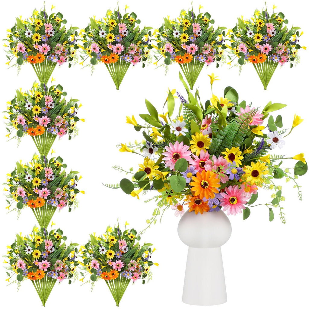 Bundle of artificial daisy wildflowers in a white vase, with multiple bouquets arranged on the left.