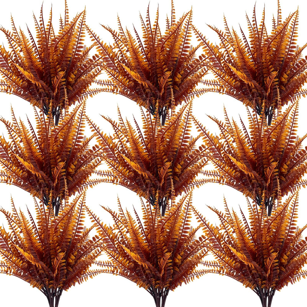 Twelve bundles of artificial fall fern and mum plants with brown and orange foliage, displayed in a grid pattern on a white background.