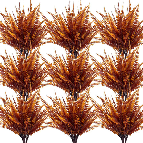 Twelve bundles of artificial fall fern and mum plants with brown and orange foliage, displayed in a grid pattern on a white background.