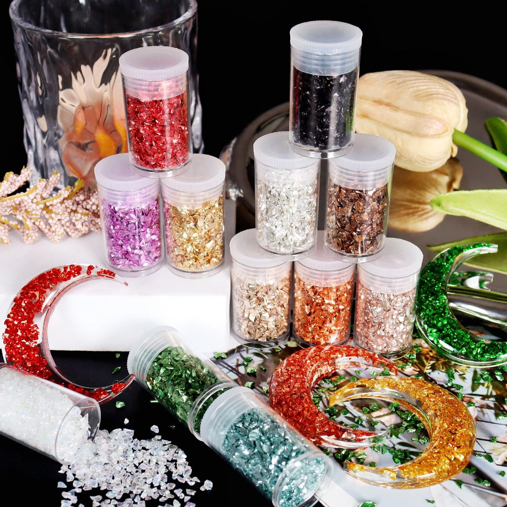 Assortment of crushed glass glitter in various colors in small plastic jars and in resin crafts.