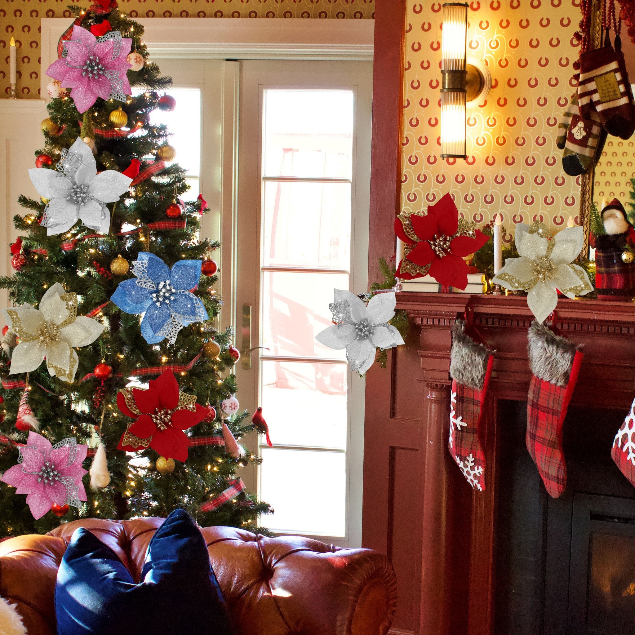 Christmas tree decorated with glitter poinsettia ornaments and stockings hung by a fireplace.