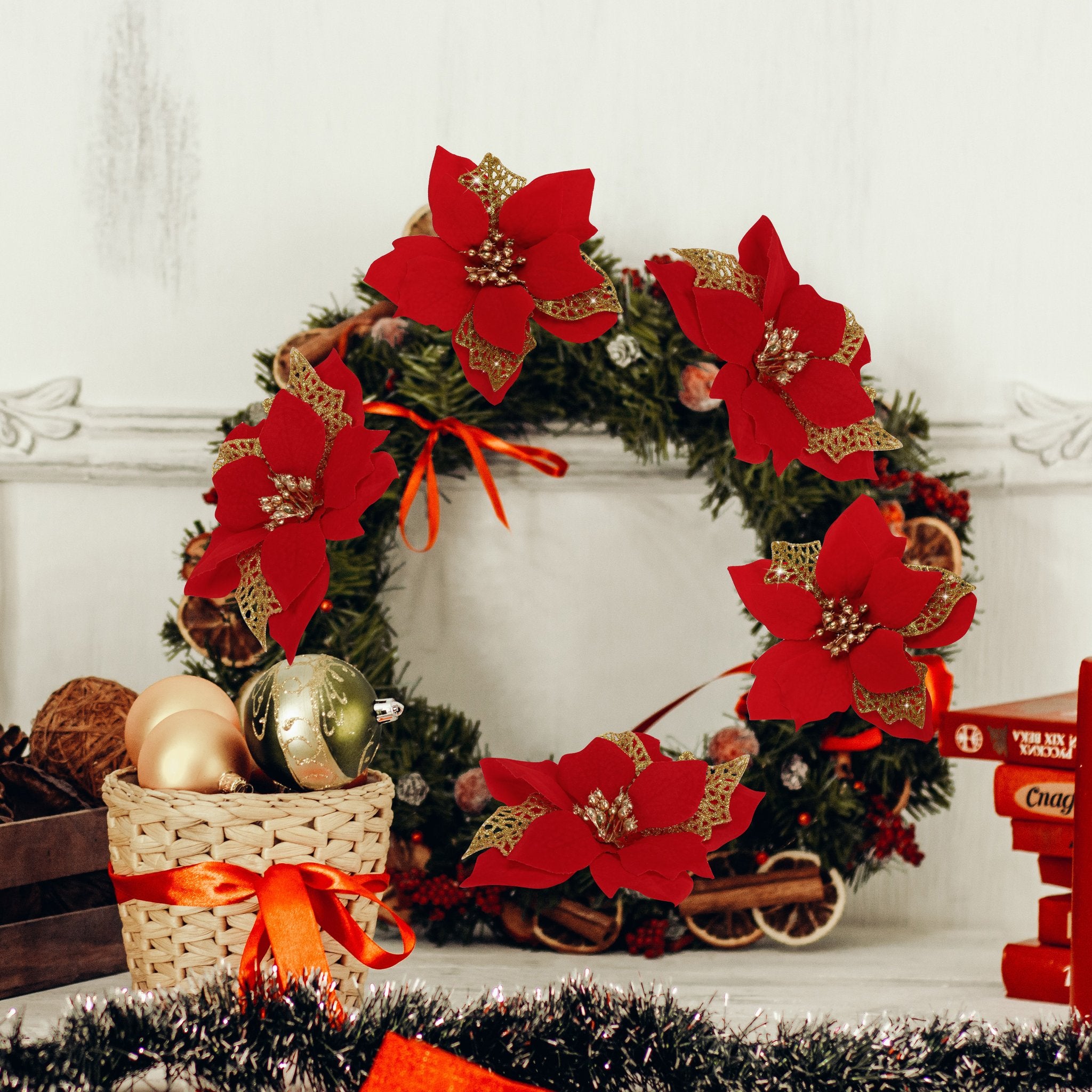 Christmas wreath decorated with red glitter poinsettia flowers, ornaments, and dried fruit