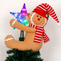 Gingerbread man tree topper with lighted star on a Christmas tree branch
