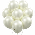 Cluster of pearlized white latex balloons with white strings against a white background.