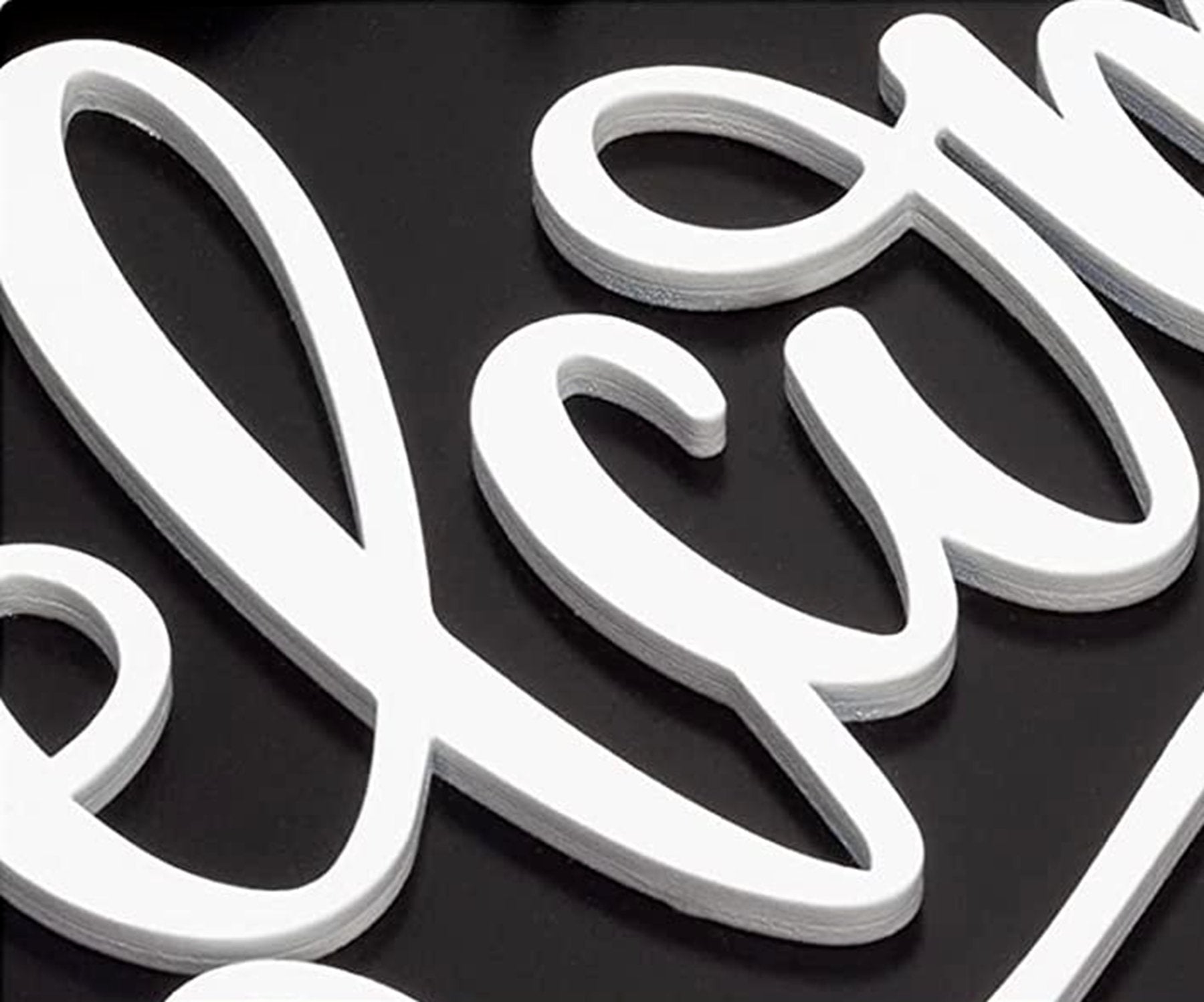 Close-up of white 3D layered script text spelling 'Welcome' on a black background.