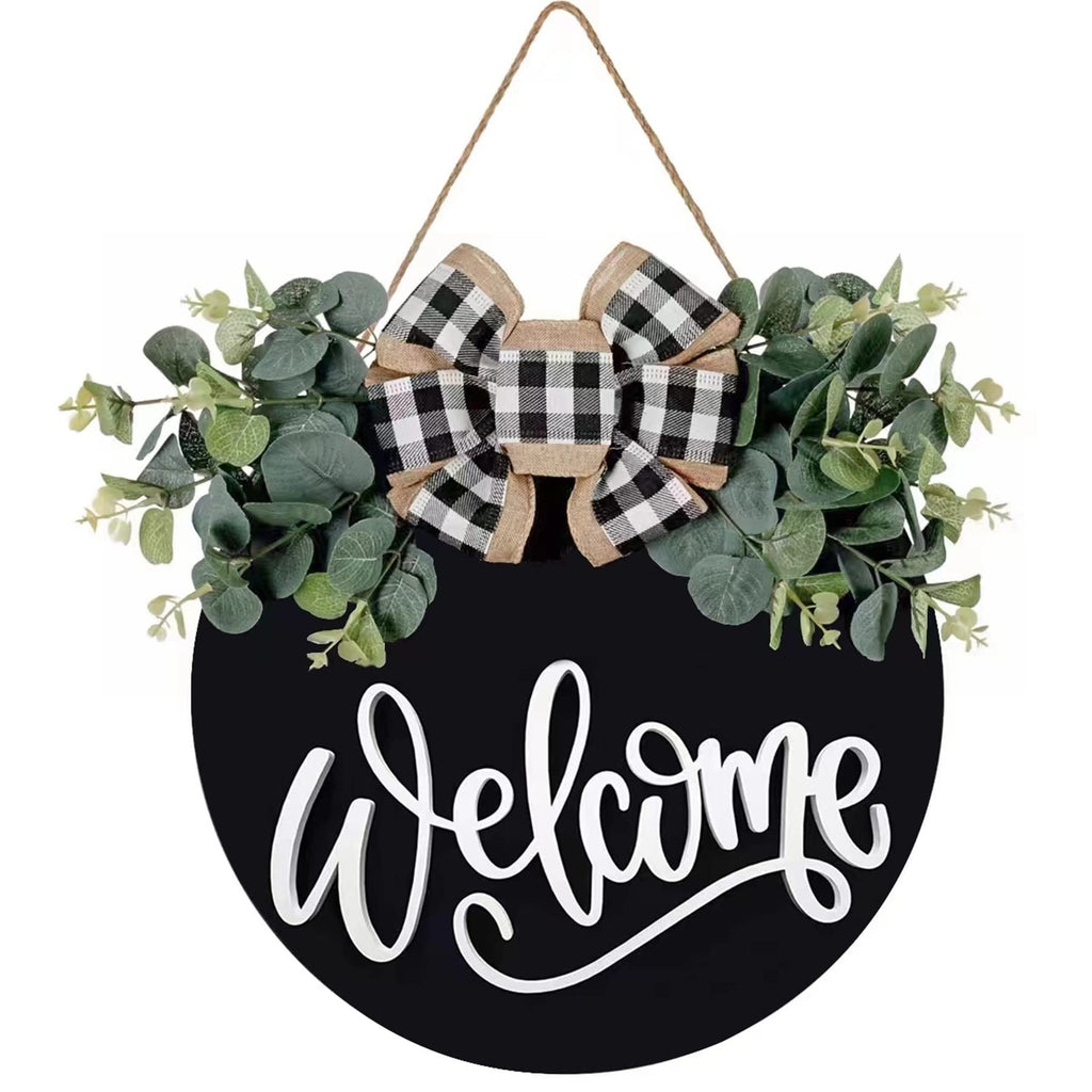 Round black wooden welcome sign with eucalyptus wreath and buffalo plaid bow