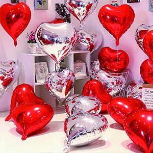 Assortment of red and silver heart-shaped foil balloons displayed in a retail setting.