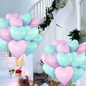 Heart-shaped foil balloons in pink and blue arranged on a staircase and in a bouquet.