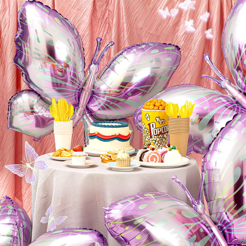 Purple gradient butterfly foil balloons arranged around a party table with cake and snacks