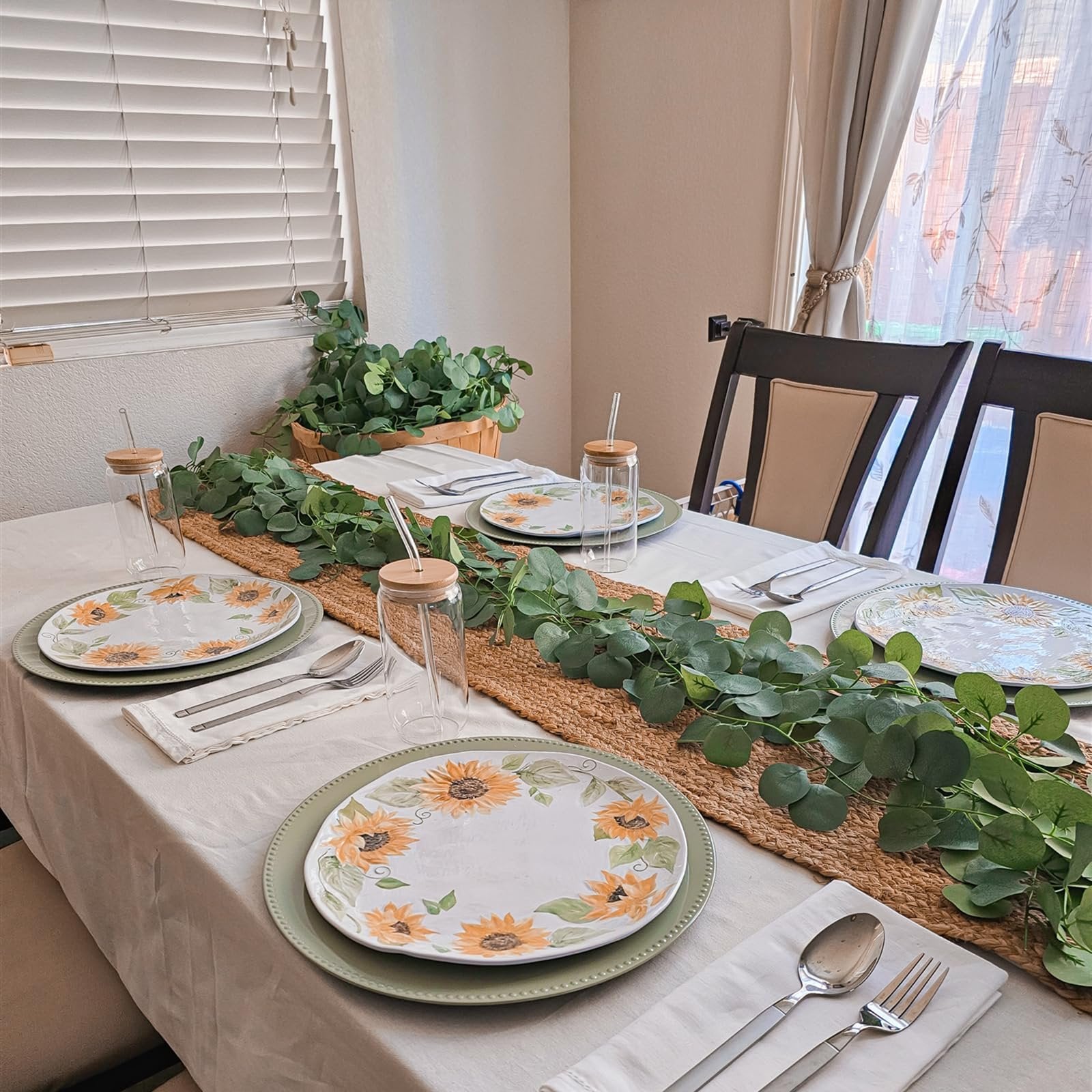 Table setting with artificial eucalyptus garland and sunflower plates