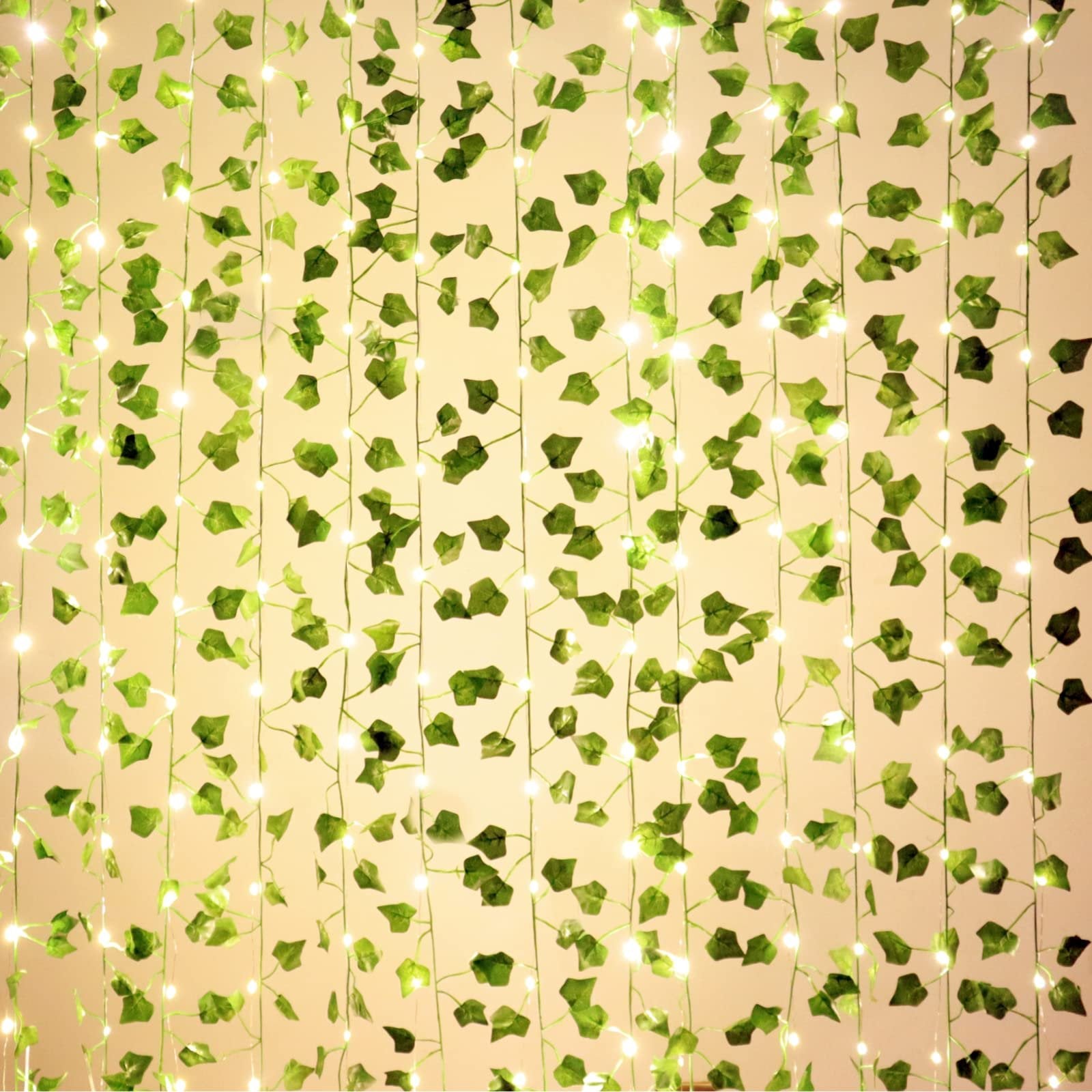 Artificial ivy vine garland with 100 LED string lights hanging vertically against a light background.