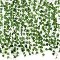 Artificial ivy vines with green silk leaves and plastic stems cascading against a white background.
