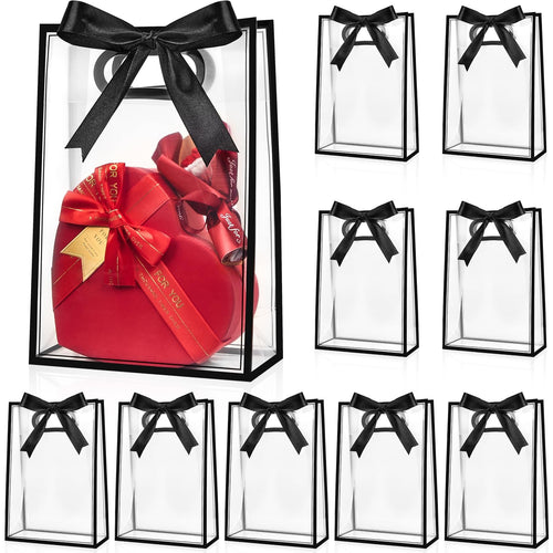 Clear plastic gift bags with black ribbon bows, one bag contains a red heart-shaped gift box.
