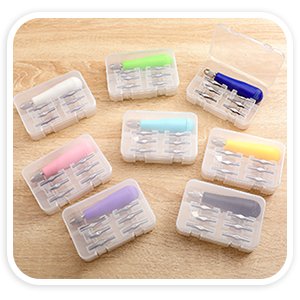Craft linoleum cutter kit with assorted V and U shape blades and handles in clear cases, arranged on a wooden surface.