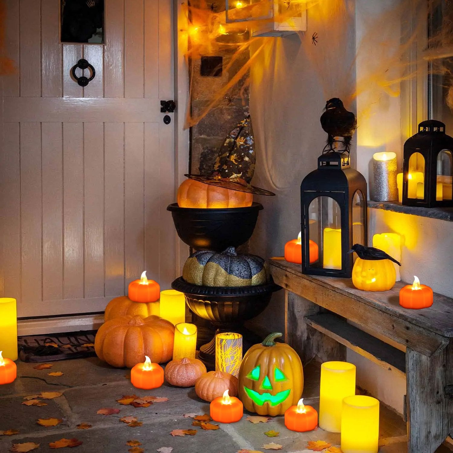 Halloween porch decorated with LED orange pumpkin tea lights and large pillar candles, with a carved jack-o'-lantern and decorative crows.