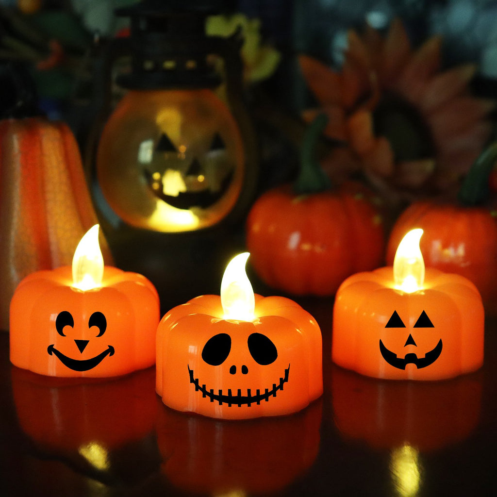 Three orange LED pumpkin tea lights with flickering flames and carved faces on a dark reflective surface.