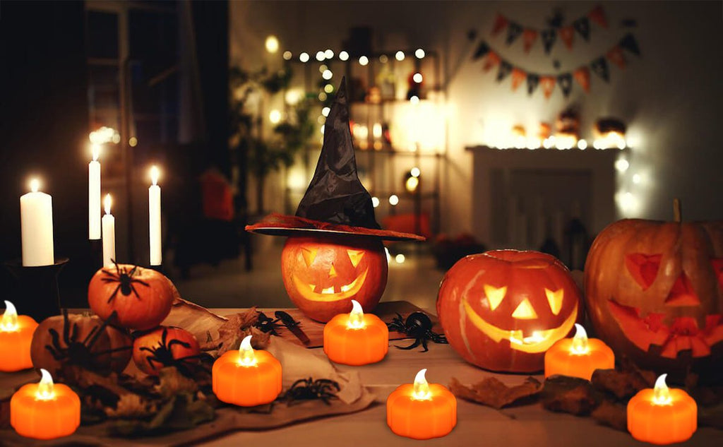 Halloween scene with carved pumpkins, LED flickering tea lights, and decorative spiders on a table with a blurred background.