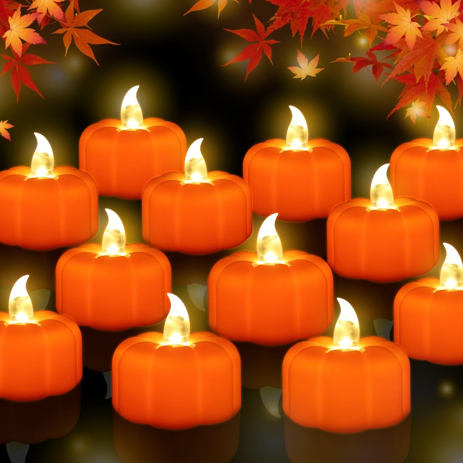A dozen orange LED pumpkin tea lights with flickering flames arranged in rows on a dark reflective surface, with autumn leaves at the top.