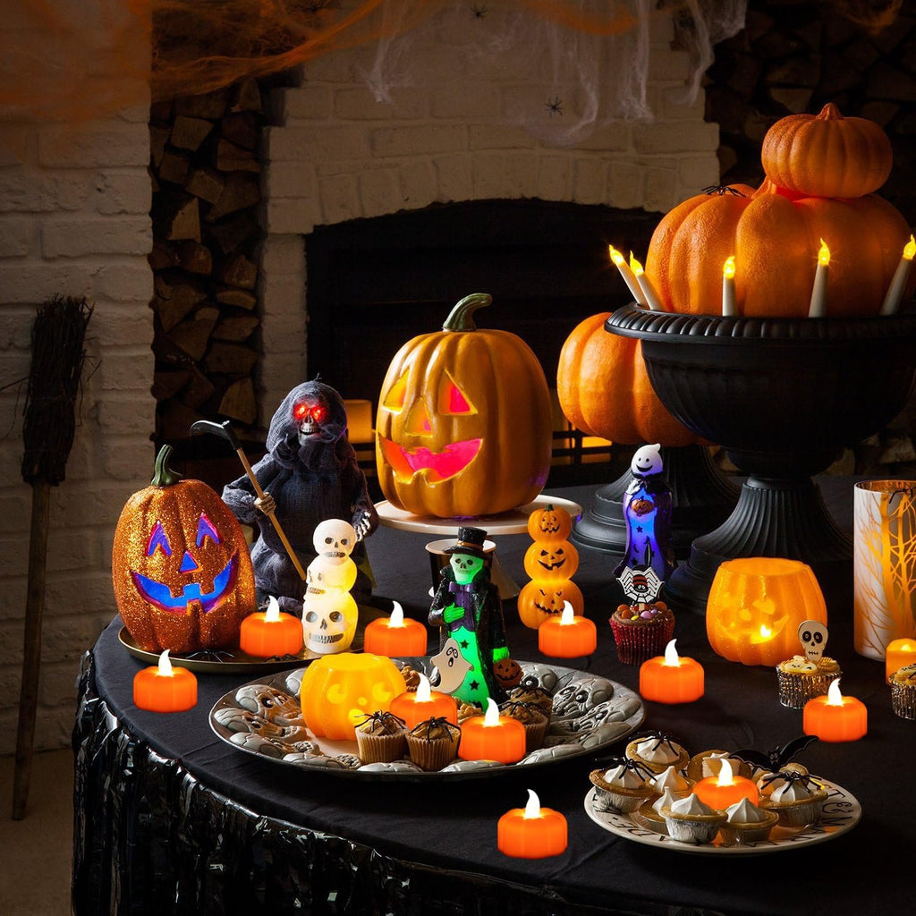 Halloween table setting with flickering LED pumpkin tea lights, carved pumpkins, and spooky decorations.