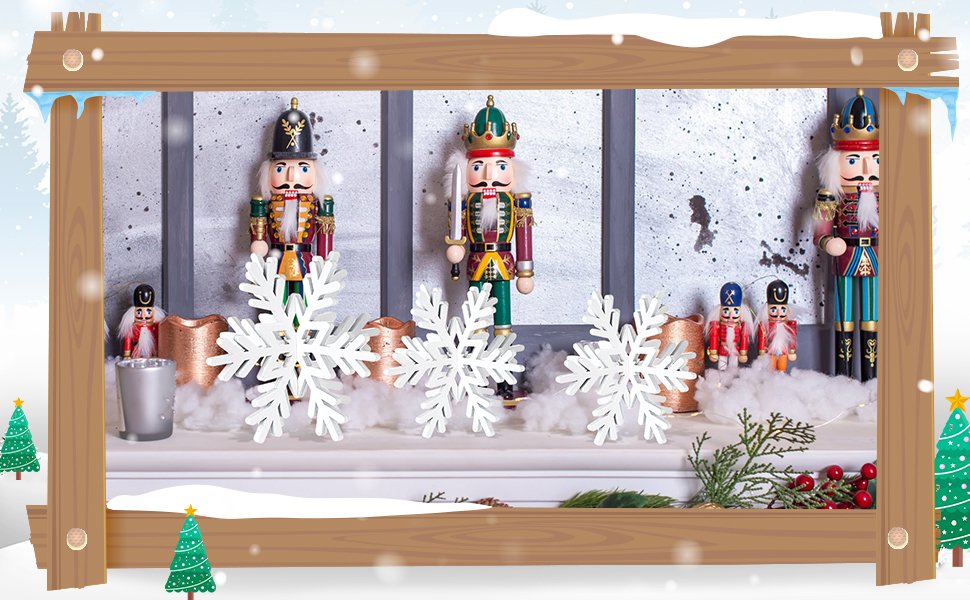 Christmas nutcracker figures and white snowflakes arranged on a mantelpiece with festive greenery and berries.