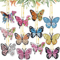 Collection of 12 diamond painting butterfly keychains hanging with gold chains against a floral background.