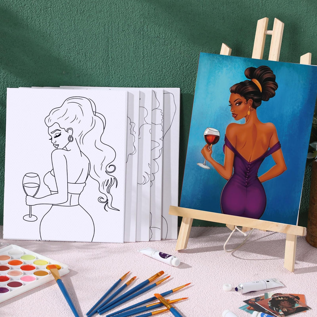 Two pre-drawn canvases for painting, one outlined and one fully painted, with art supplies like brushes and paint tubes on a pink surface.