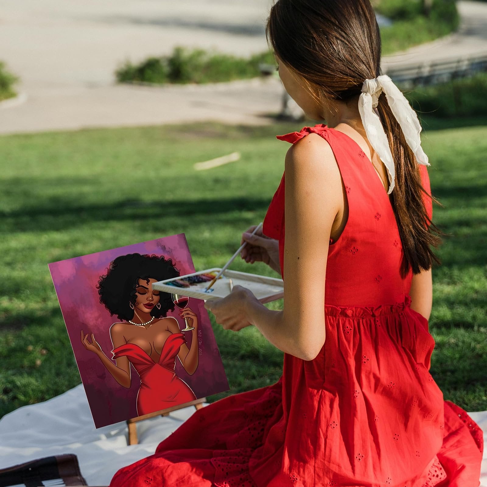 Woman in red dress painting a stylish lady with wine on canvas in a park
