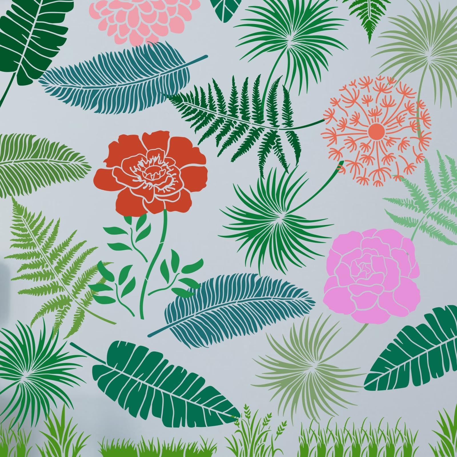 Floral and leaf stencils with grass at the bottom on a light gray background
