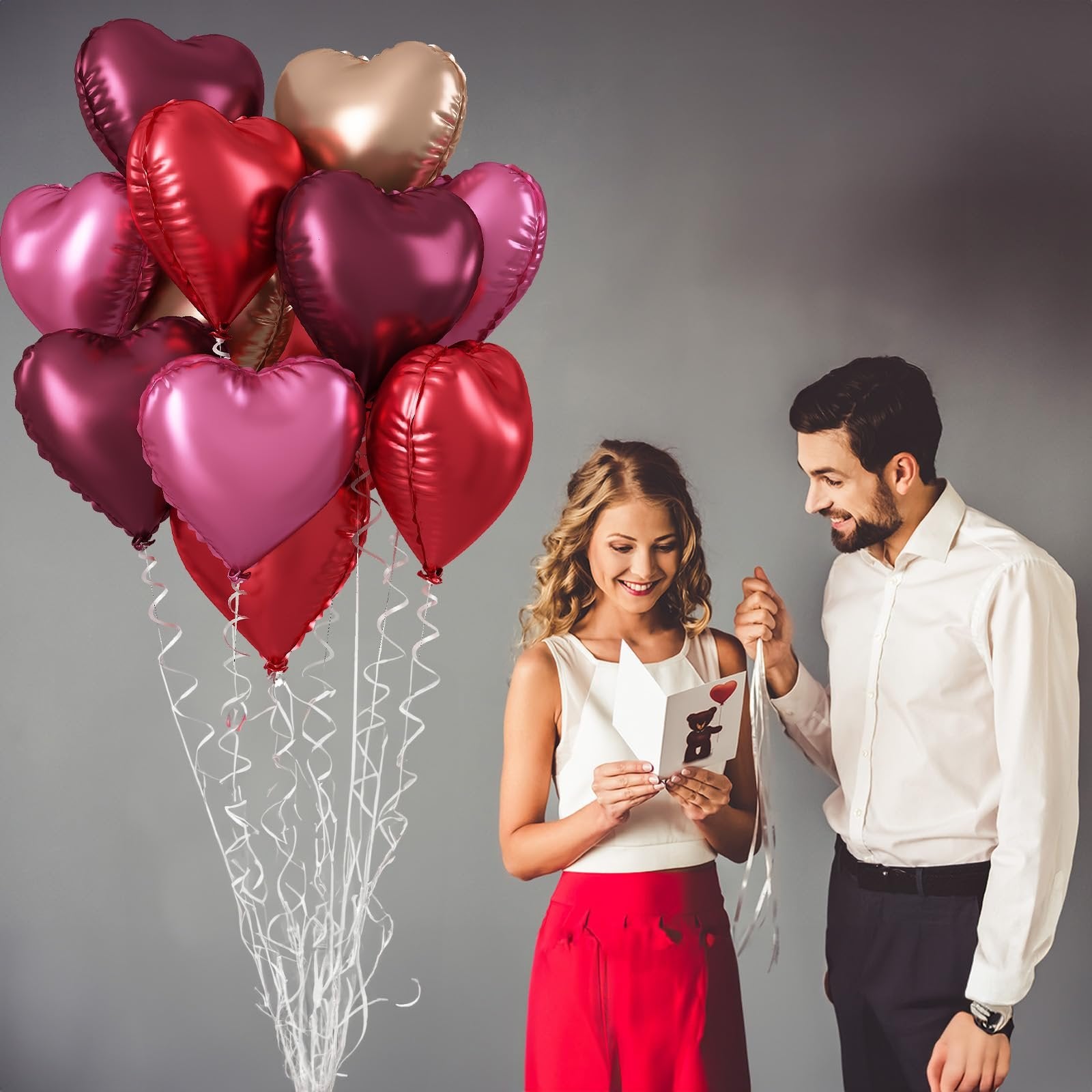 Couple celebrating with a bouquet of heart-shaped balloons and a greeting card