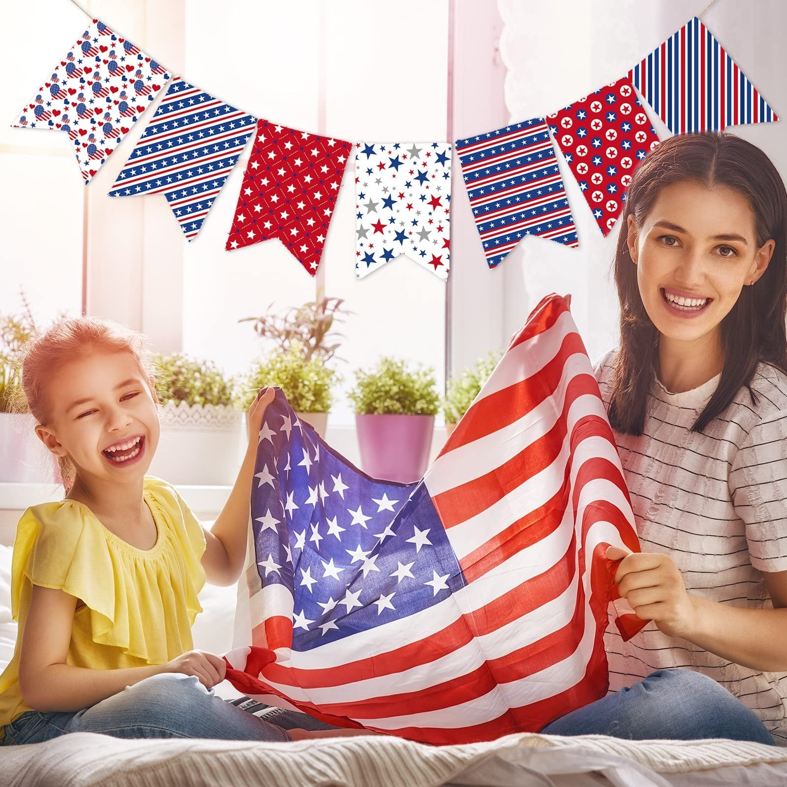 Mother and daughter holding an American flag with patriotic bunting in the background