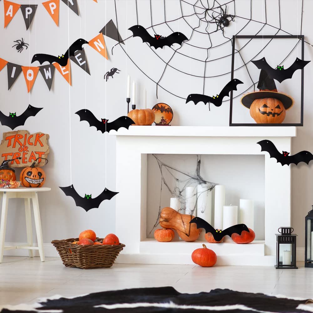 Halloween fireplace decor with hanging bats, pumpkins, spider web, and 'Trick or Treat' sign.