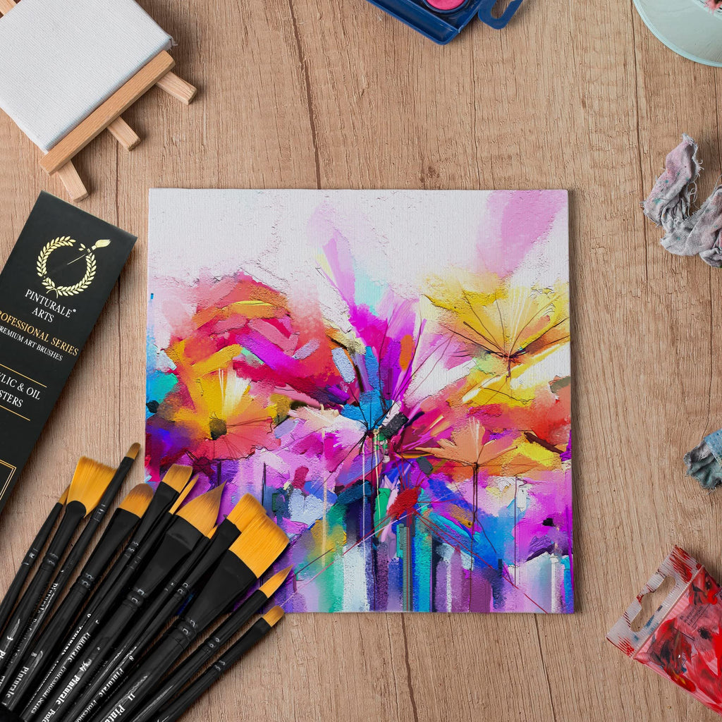 Acrylic and oil paint brushes with a colorful abstract painting on canvas, arranged on a wooden surface.