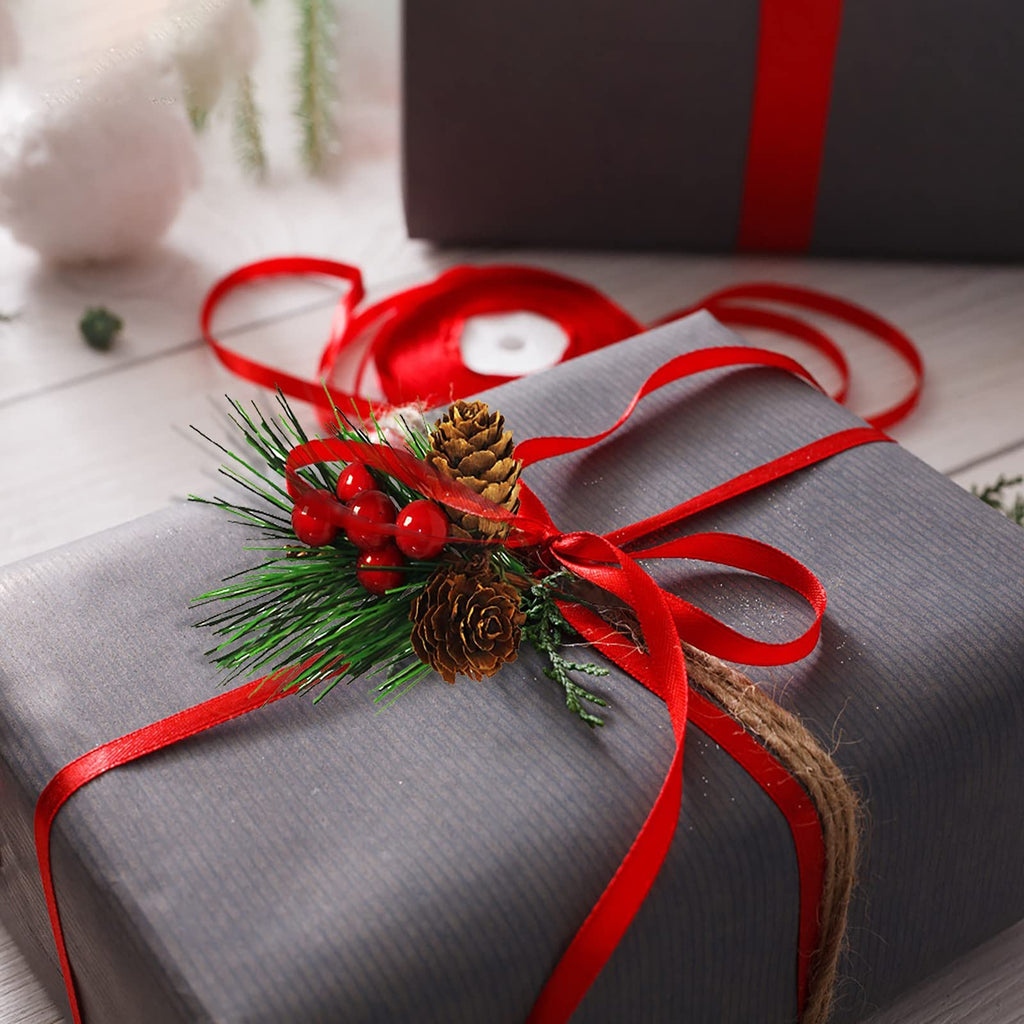 Christmas gift wrapped in gray paper with red ribbon and pine branch decoration