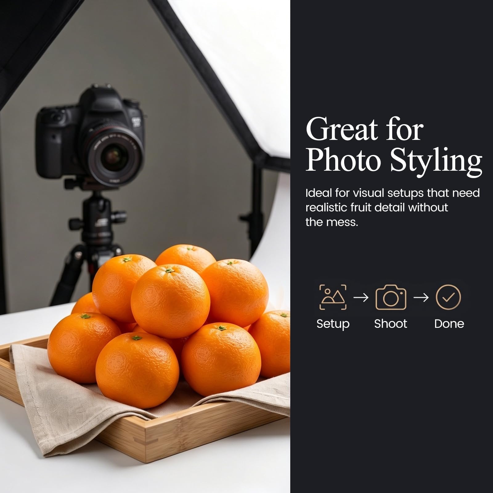 Artificial oranges in a wooden tray with a camera and lighting setup in the background.