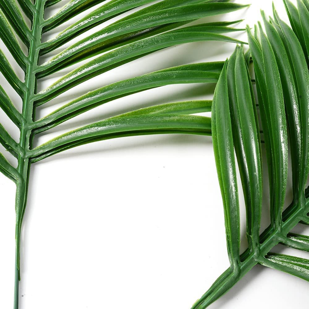 Close-up of two artificial palm leaves with green stems and long, slender fronds against a white background.