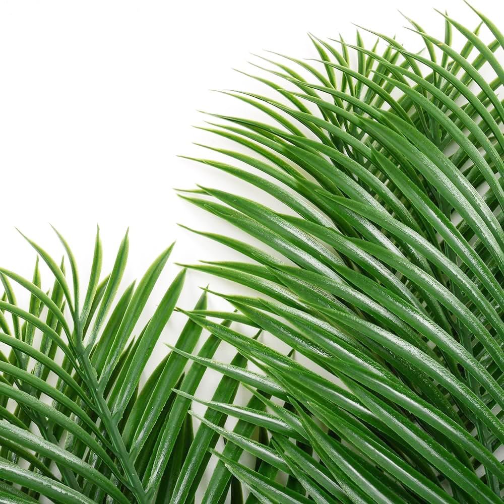 Close-up of two artificial palm leaves with vibrant green fronds against a white background.