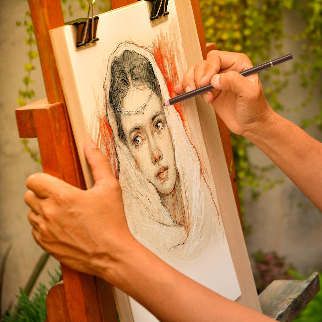 Artist's hands sketching a portrait on an easel with colored charcoal pencils