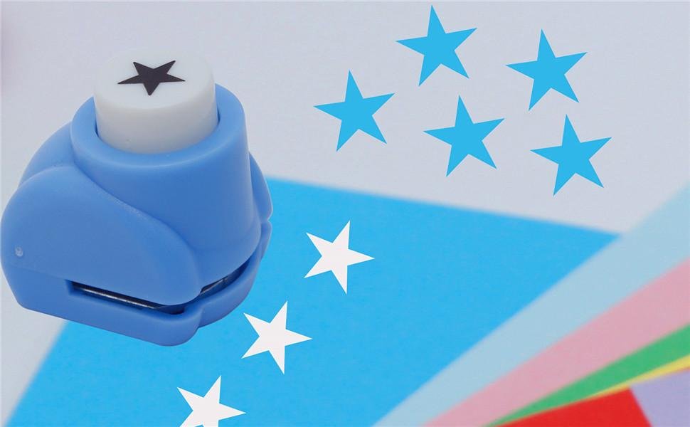 Blue star craft puncher on a surface with cut-out stars and colored paper