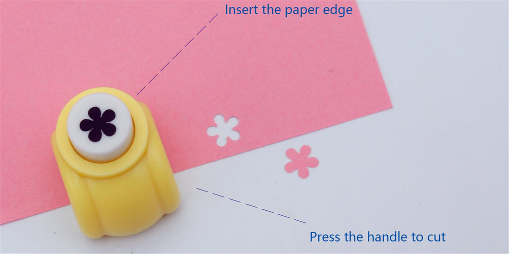 Yellow flower-shaped craft puncher creating cutouts in pink paper on a white surface