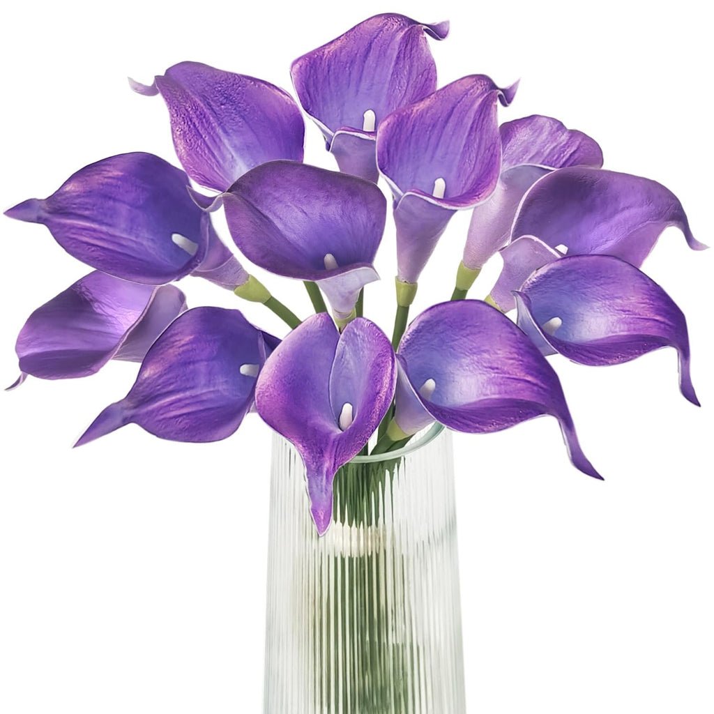 Purple calla lily artificial flower bouquet in a clear glass vase, close-up view