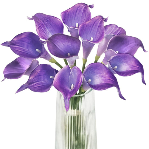 Purple calla lily artificial flower bouquet in a clear glass vase, close-up view